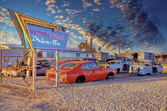 Bombay Beach Drive-In installation in California, featuring rows of old, rusted cars facing a movie screen in an abandoned, surreal desert town.