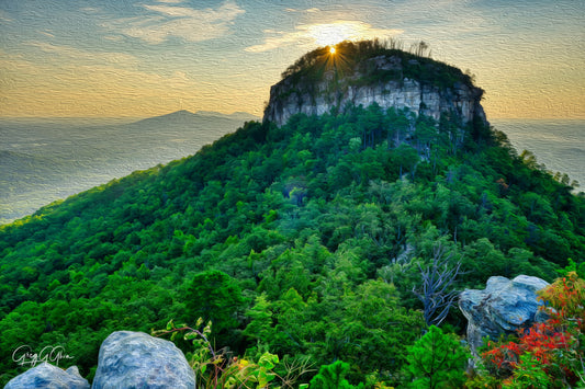 Sunrise over Pilot Mountain, North Carolina—distinctive peak towers above the Piedmont plateau, bathed in warm morning light.