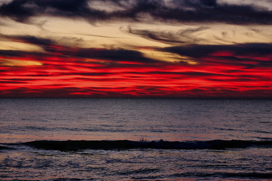 Sunrise over Carolina Beach, North Carolina, with vivid red sky, gray clouds, and deep ocean waters.