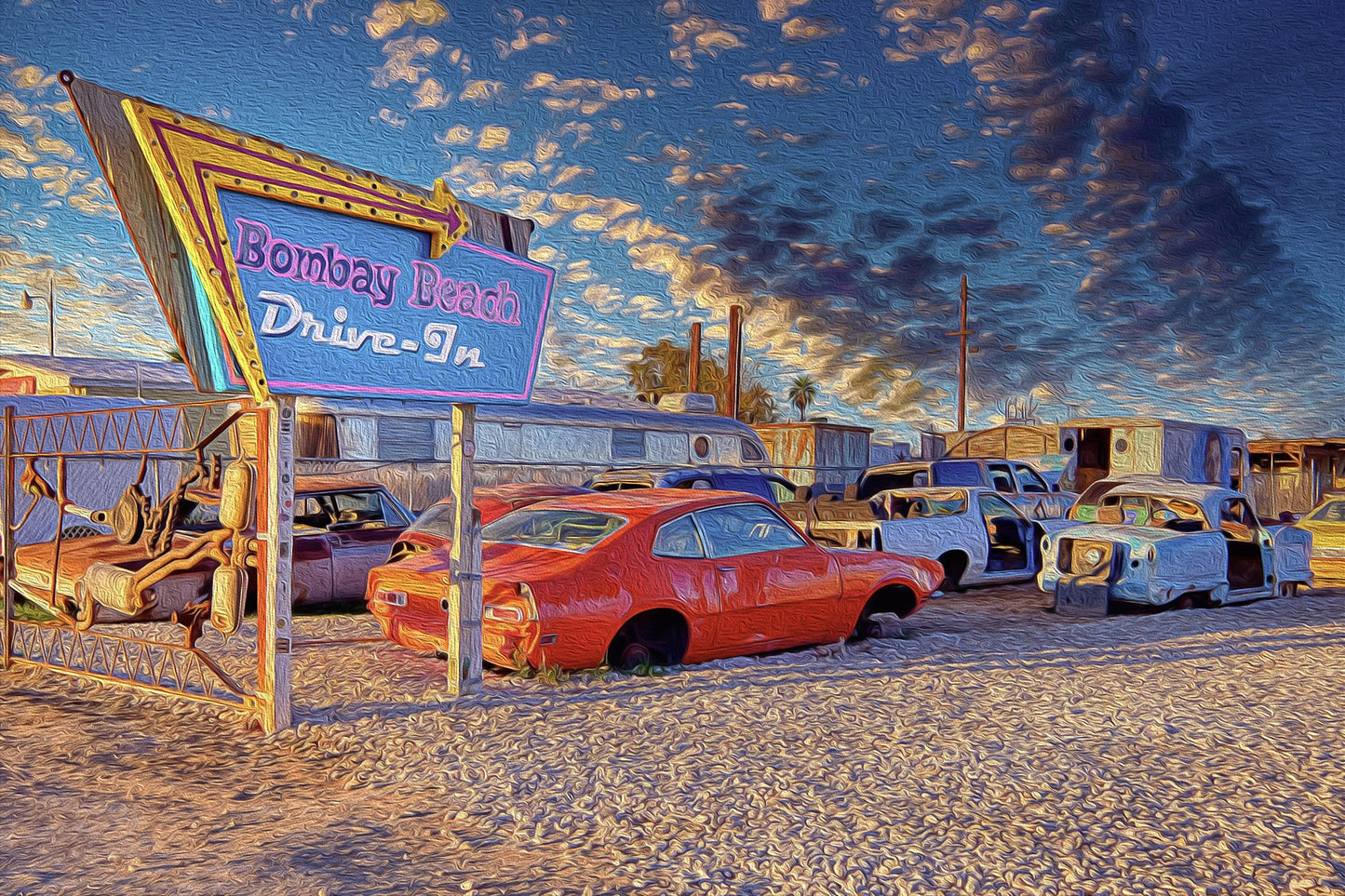 Bombay Beach Drive-In installation in California, featuring rows of old, rusted cars facing a movie screen in an abandoned, surreal desert town.