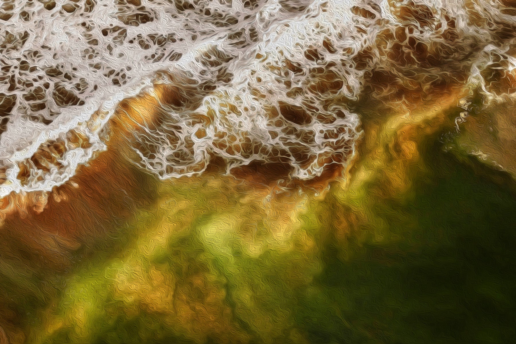 Aerial photo of jade and emerald waves breaking on the coast of Cannon Beach, Oregon.