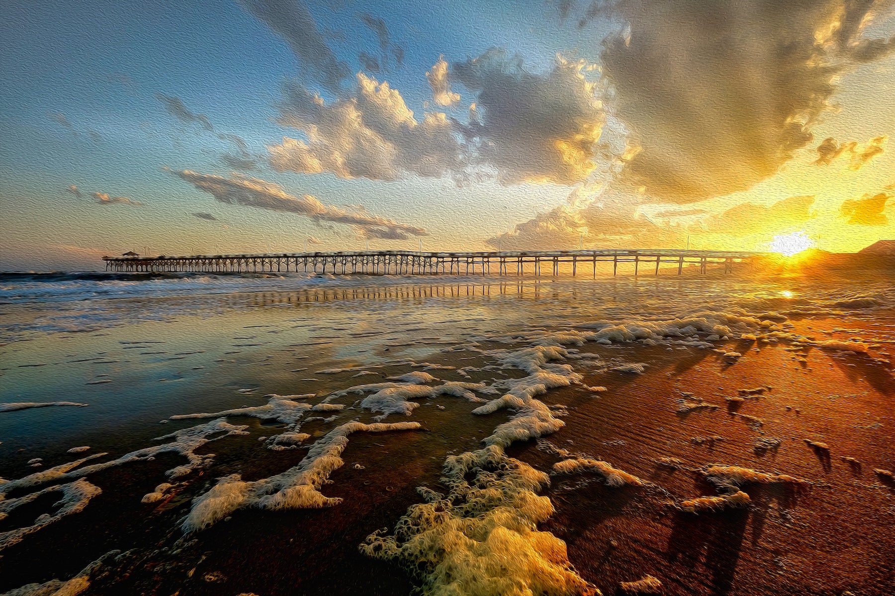 Colorful sunset over Oceancrest Pier in Oak Island, North Carolina, with vivid skies and the pier stretching toward the ocean.