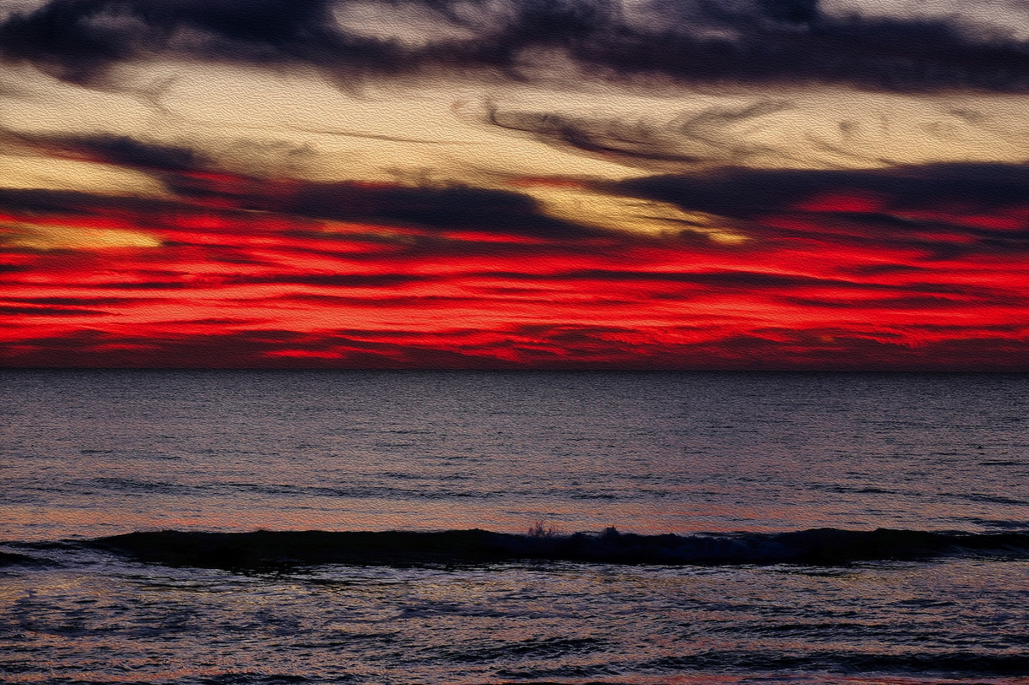 Sunrise over Carolina Beach, North Carolina, with vivid red sky, gray clouds, and deep ocean waters.